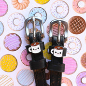 Front view of the buckled Coffee Mane Jane Spur Straps on a pastry background