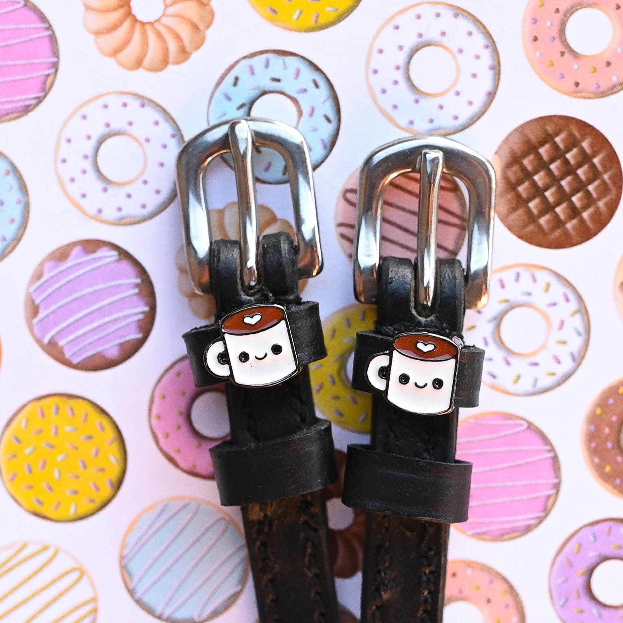 Front view of the buckled Coffee Mane Jane Spur Straps on a pastry background