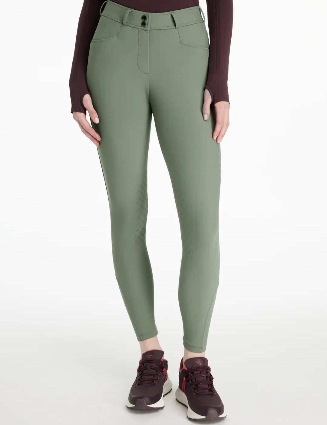 Front view of a model wearing the green LeMieux Isabelle Knee Grip Breeches on a white background