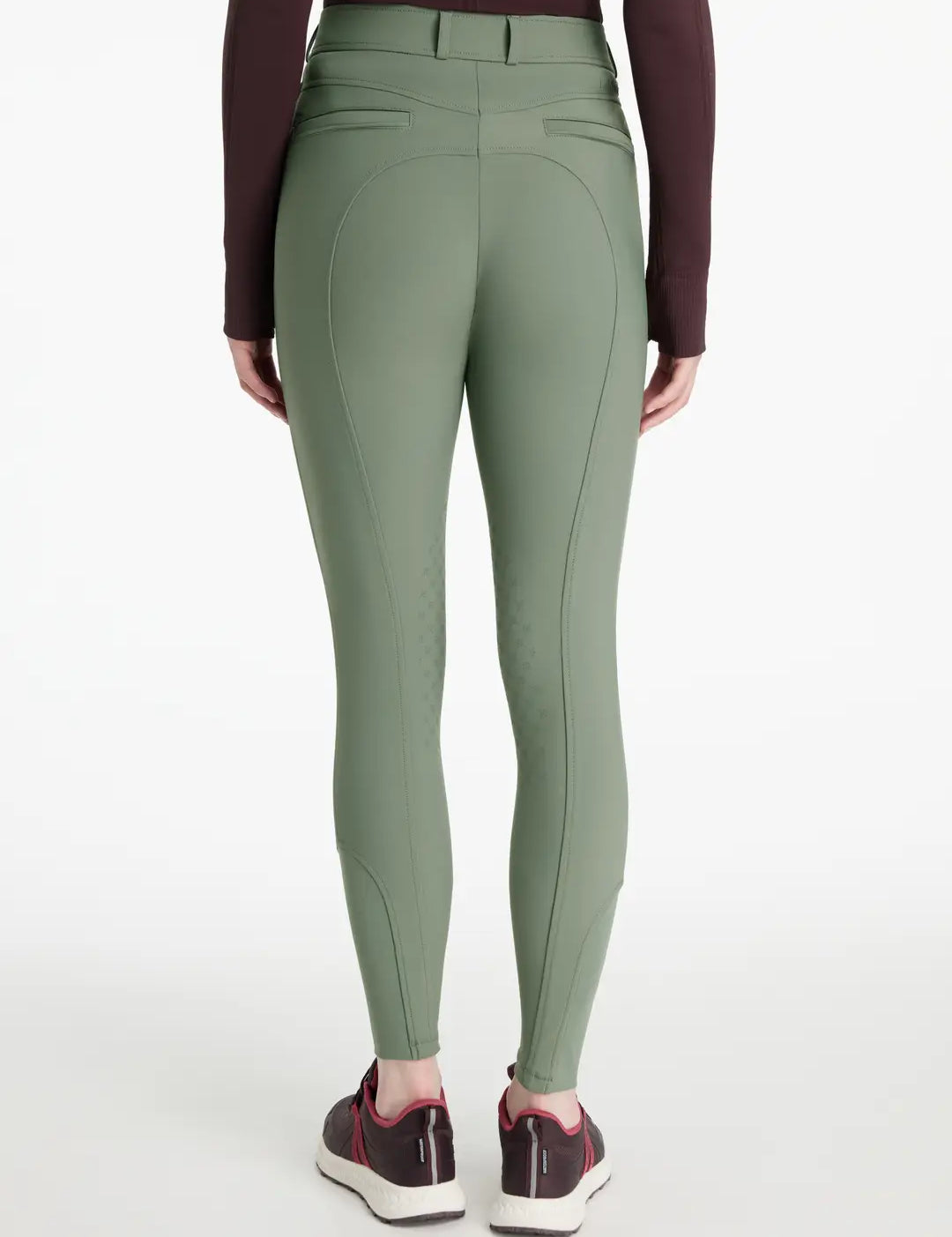 Back view of a model wearing the green LeMieux Isabelle Knee Grip Breeches on a white background