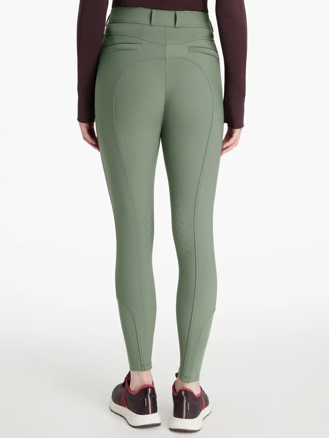 Back view of a model wearing the green LeMieux Isabelle Knee Grip Breeches on a white background