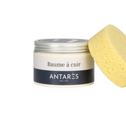 Front view of a jar of Antares Baume A Cuir with a yellow sponge leaned up against it on a white background
