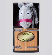 Front view of a gray Crafty Ponies Horseware Pony stuffed animal in it's cardboard box which looks like a stall