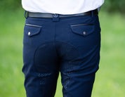 Close-up back view of a male model wearing the navy KL Select Men's Evan Full Seat Breeches while standing outside