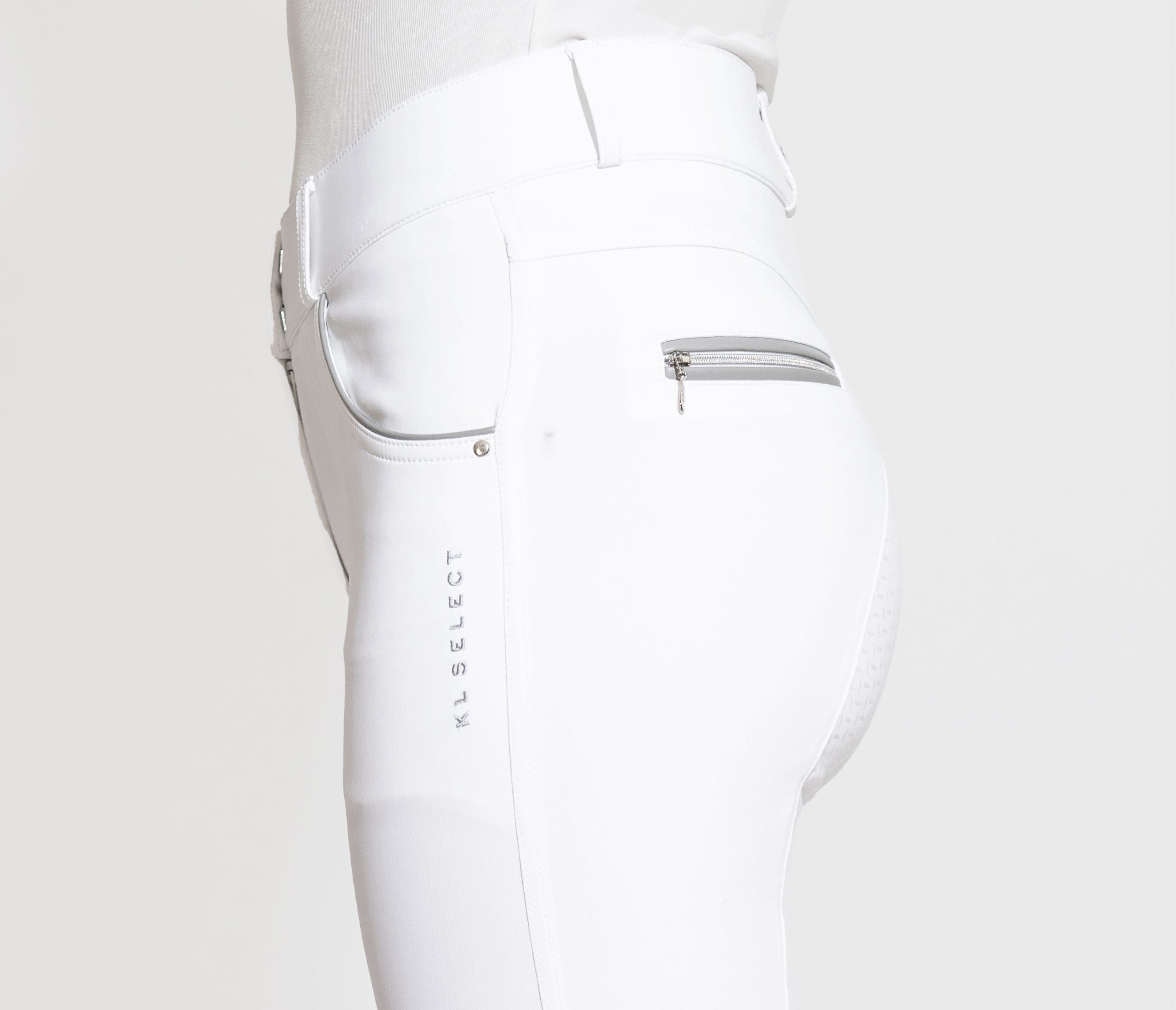 Close-up side view of a model wearing the white KL Select Gabrielle Full Seat Breech on a white background
