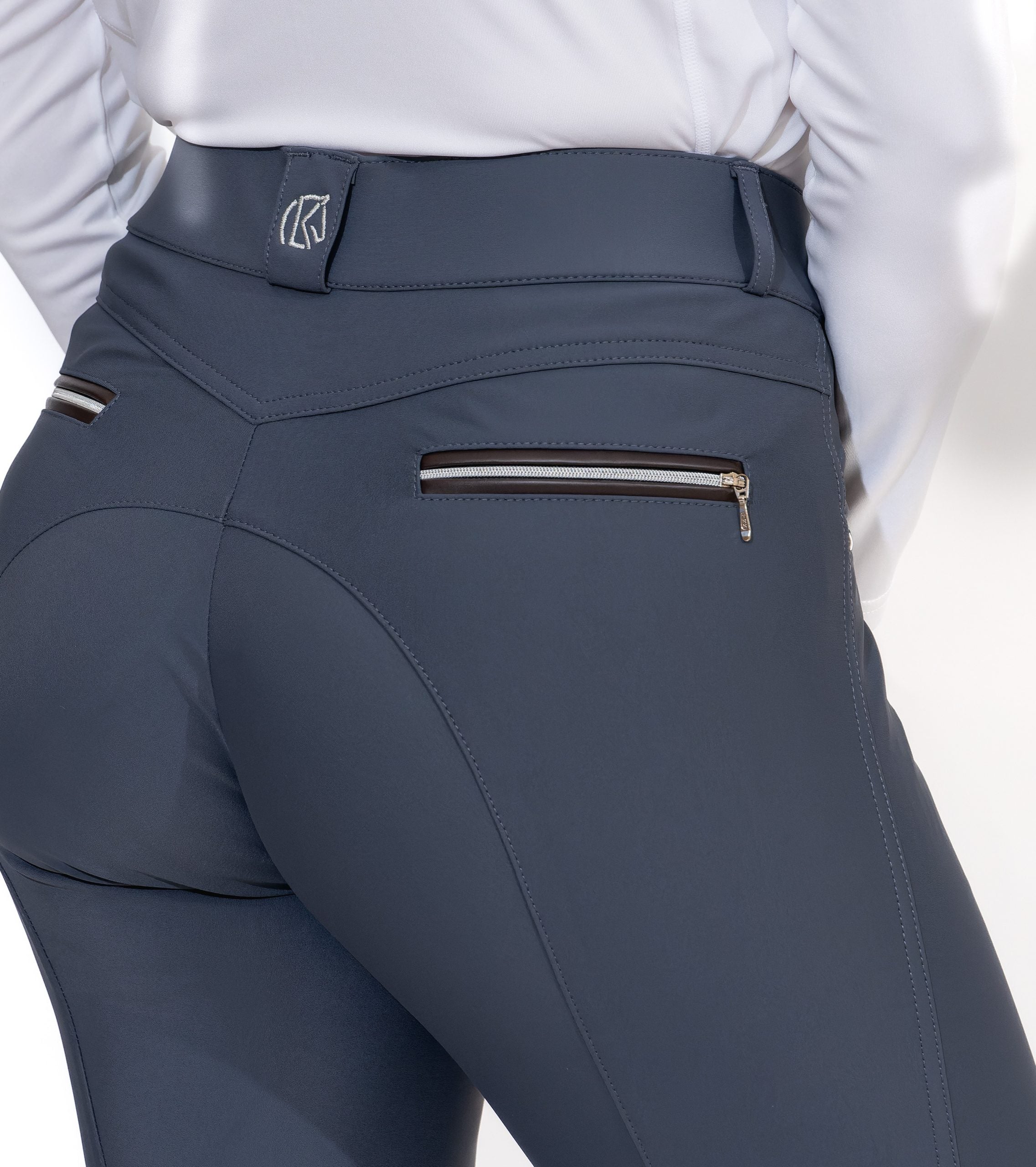Close-up back view of a model wearing the slate blue KL Select Gabrielle Knee Patch Breech on a white background
