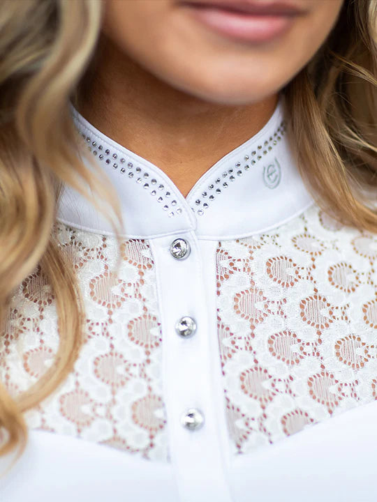 Close-up front view of a female model wearing the white Equestrian Stockholm Crystal Champion Competition Top