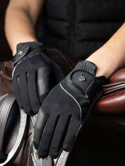 Person wearing black LeMieux Crystal Gloves with hands laid over english saddle