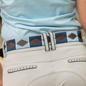 Close-up view of the light blue and navy, brown-leather Equinavia Siri Polo Belt on tan breeches
