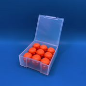 A clear plastic storage box with an open lid containing multiple round orange studs, photographed on a blue gradient background.