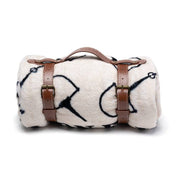 View of the rolled up snaffle Blue Stallion Farm Flannel Fleece Blanket in Leather Holder on a white background
