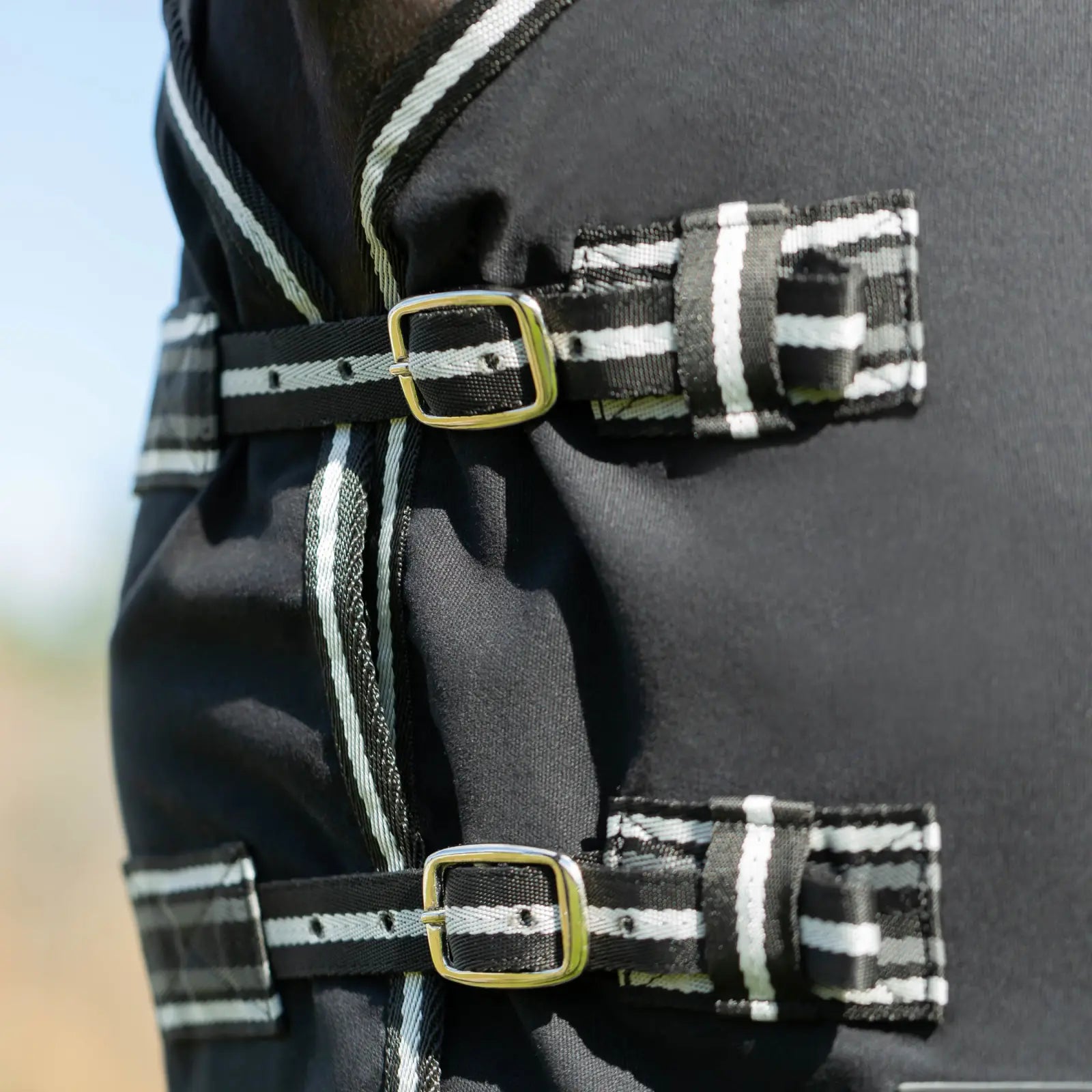 Front view of the chest closures on the black Equinavia Fryd Cotton Stable Sheet