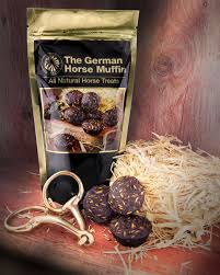 Front view of a bag Equus Magnificus The German Horse Muffin on a wood shelf with a bit, 3 muffins, and some hay