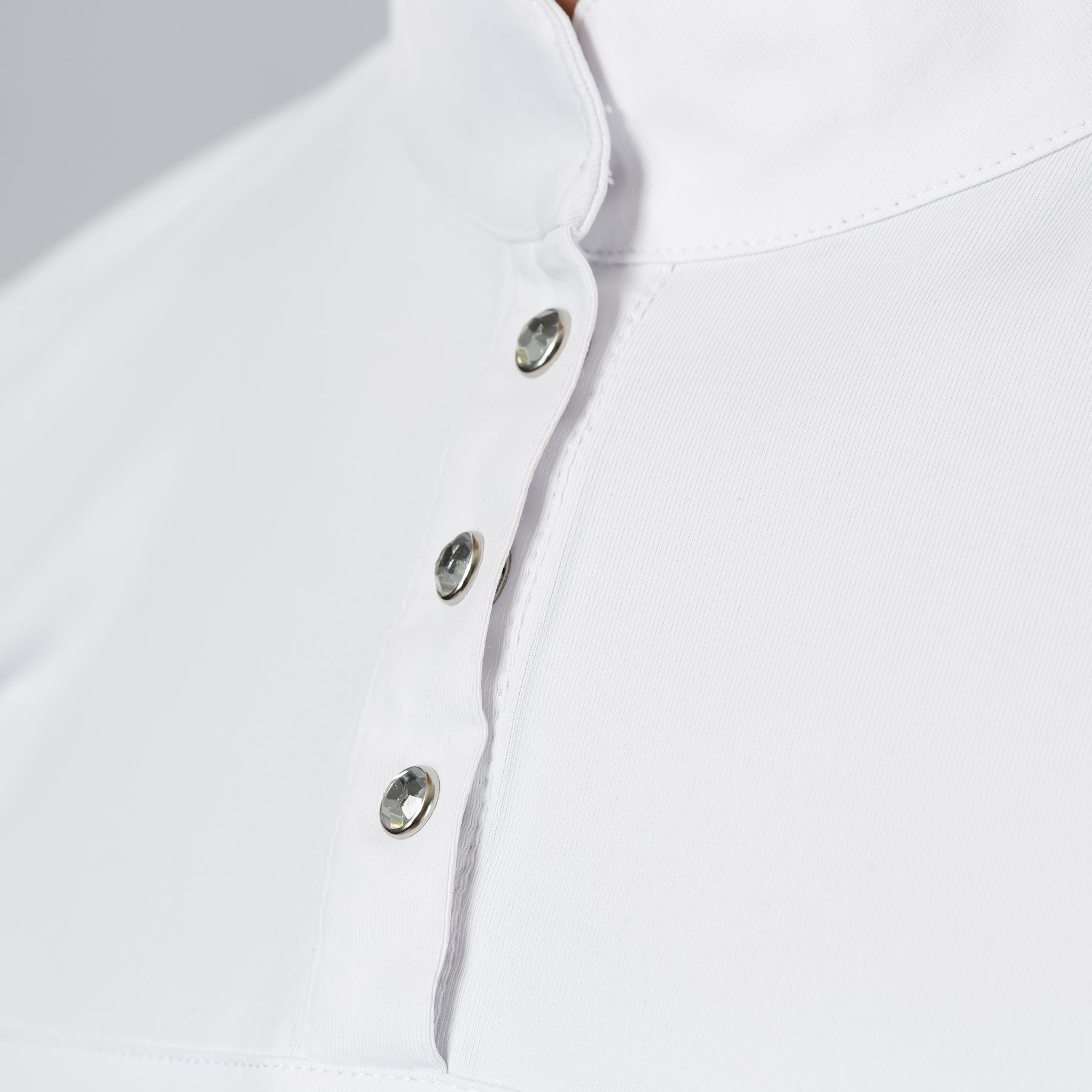 Close-up front view of a female model wearing the white Horze Mina Short Sleeve Crystal Show Shirt