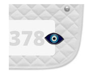 Side view of a white pad with numbers 378 and an Evil Eye Dubois Cheval Number Pin Charm on a white background