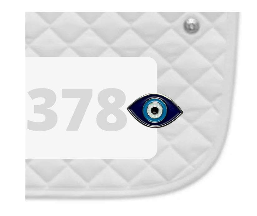 Side view of a white pad with numbers 378 and an Evil Eye Dubois Cheval Number Pin Charm on a white background