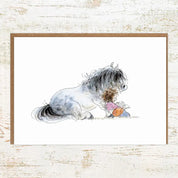 View of the Storytime Pony Nut Greeting Card on a white washed wood background