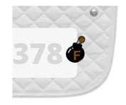 Side view of a white pad with numbers 378 and an F Bomb Dubois Cheval Number Pin Charm on a white background