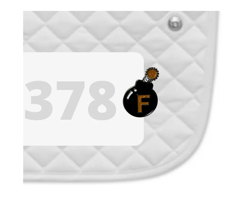 Side view of a white pad with numbers 378 and an F Bomb Dubois Cheval Number Pin Charm on a white background