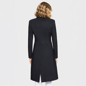 Back view of a female model wearing the black Samshield Frac Crystal Fabric Show Coat on a plain background