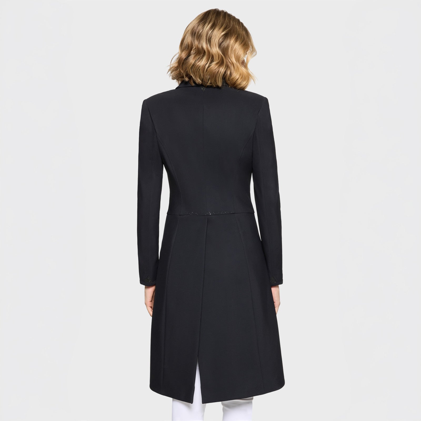 Back view of a female model wearing the black Samshield Frac Crystal Fabric Show Coat on a plain background