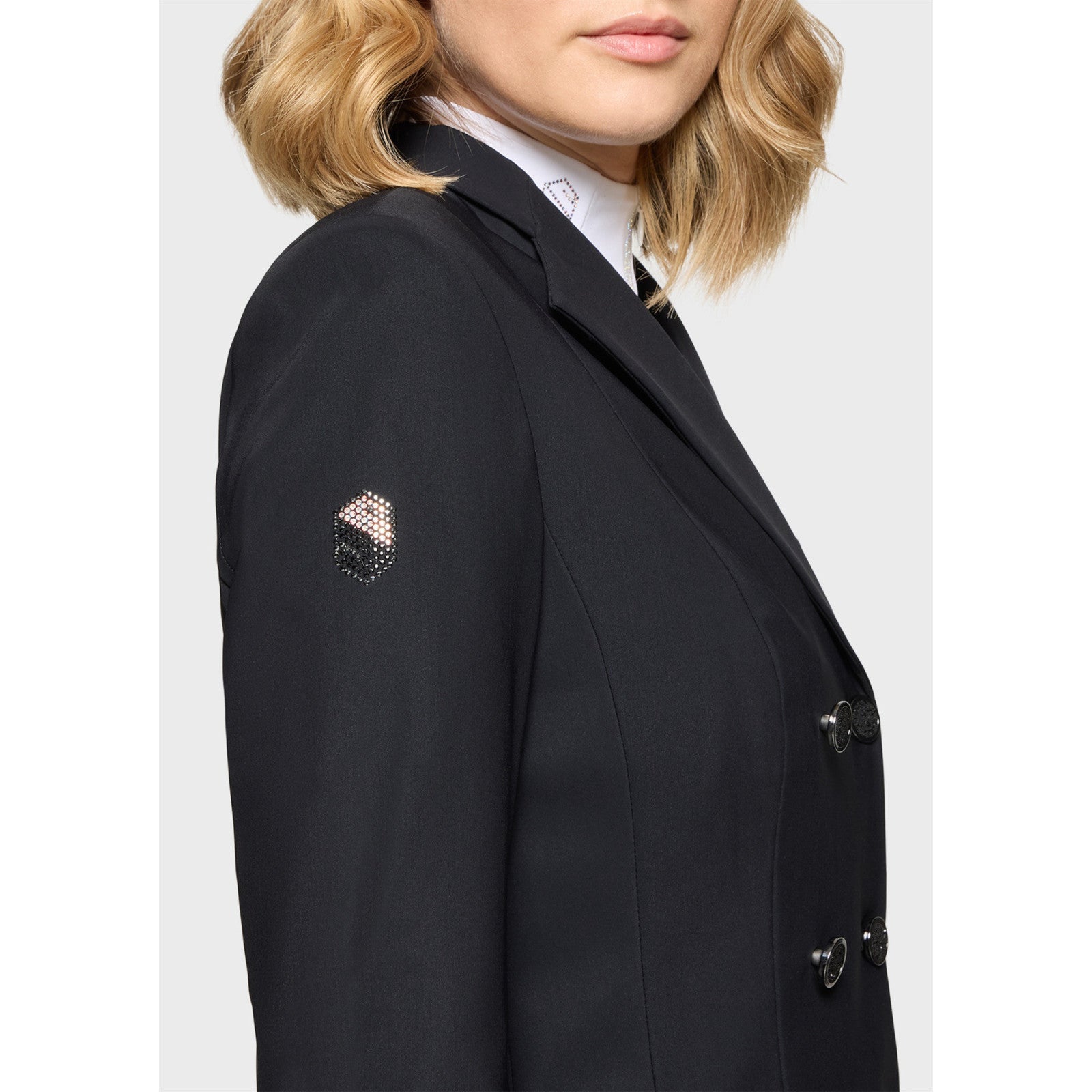 Close-up side view of a female model wearing the black Samshield Frac Crystal Fabric Show Coat on a plain background