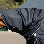 Side view of a horse wearing the black Equinavia Norse Turnout Hood 0g