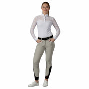 Full body front view of a female model wearing the white Equinavia Lisa Lace Long Sleeve Show Shirt with tan breeches on a white background