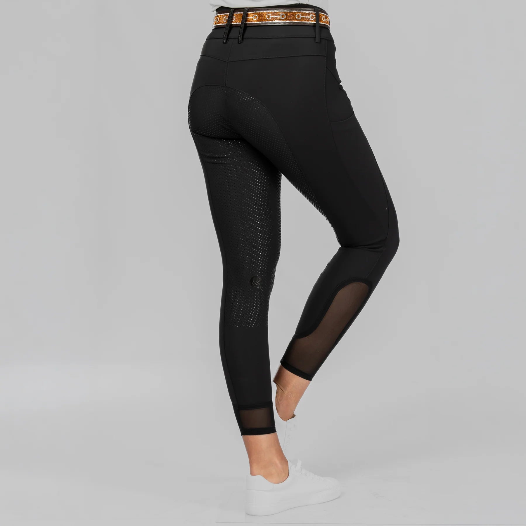 Back view of a model wearing Black Equinavia Sissel Full Seat Breeches on a plain background
