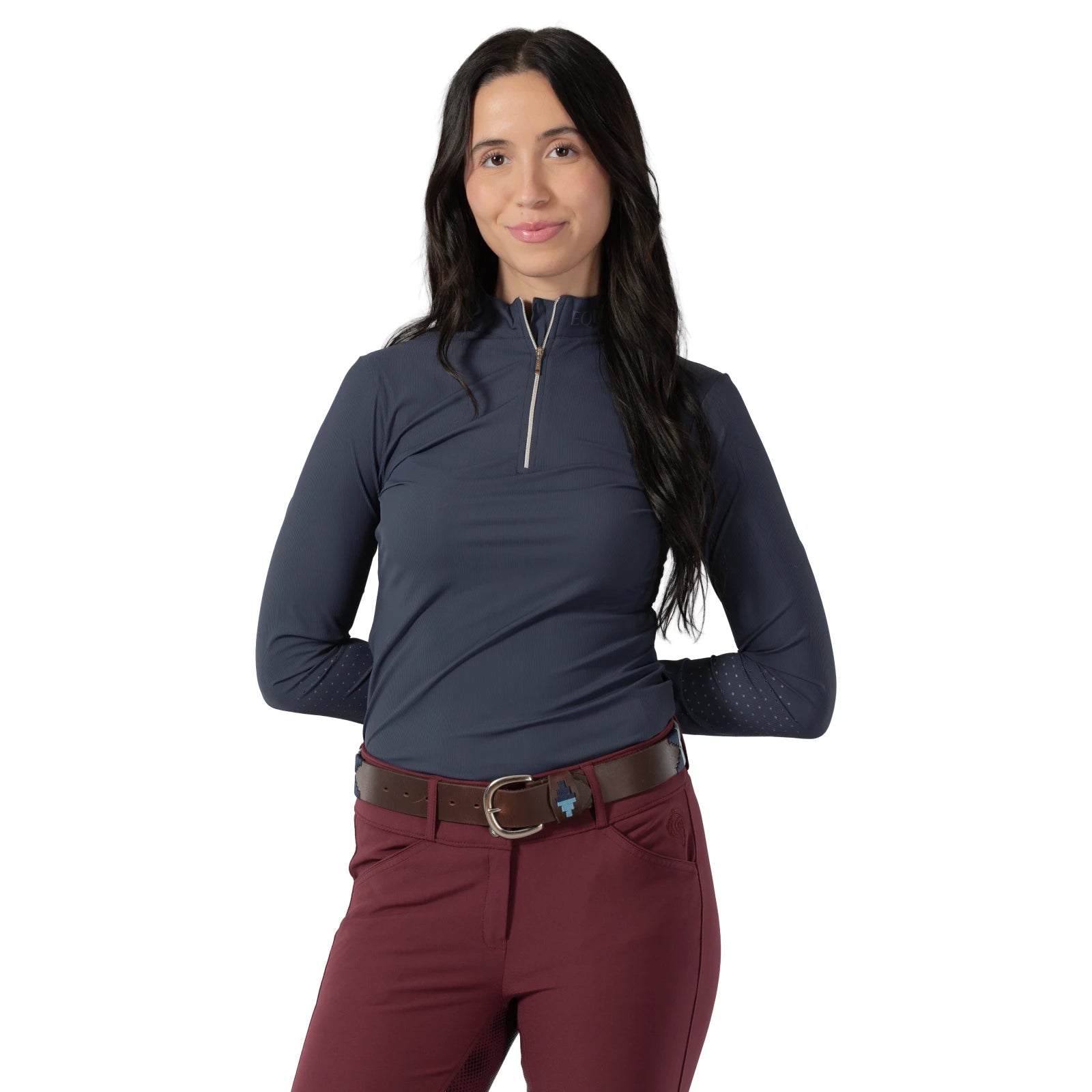 Front view of a model wearing a blut top, maroon breeches, and the light blue and navy, brown-leather Equinavia Siri Polo Belt on a white background