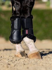 Horse wearing black LeMieux Fleece Edged Brushing Boots standing on sand