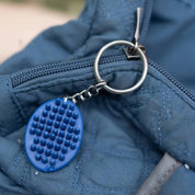 View of the blue Horze Brush Key Chain on a blue zipper
