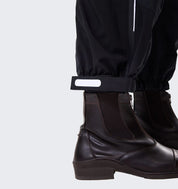 Close-up of Horseware H2O Trousers in black showing adjustable ankle strap above paddock boot