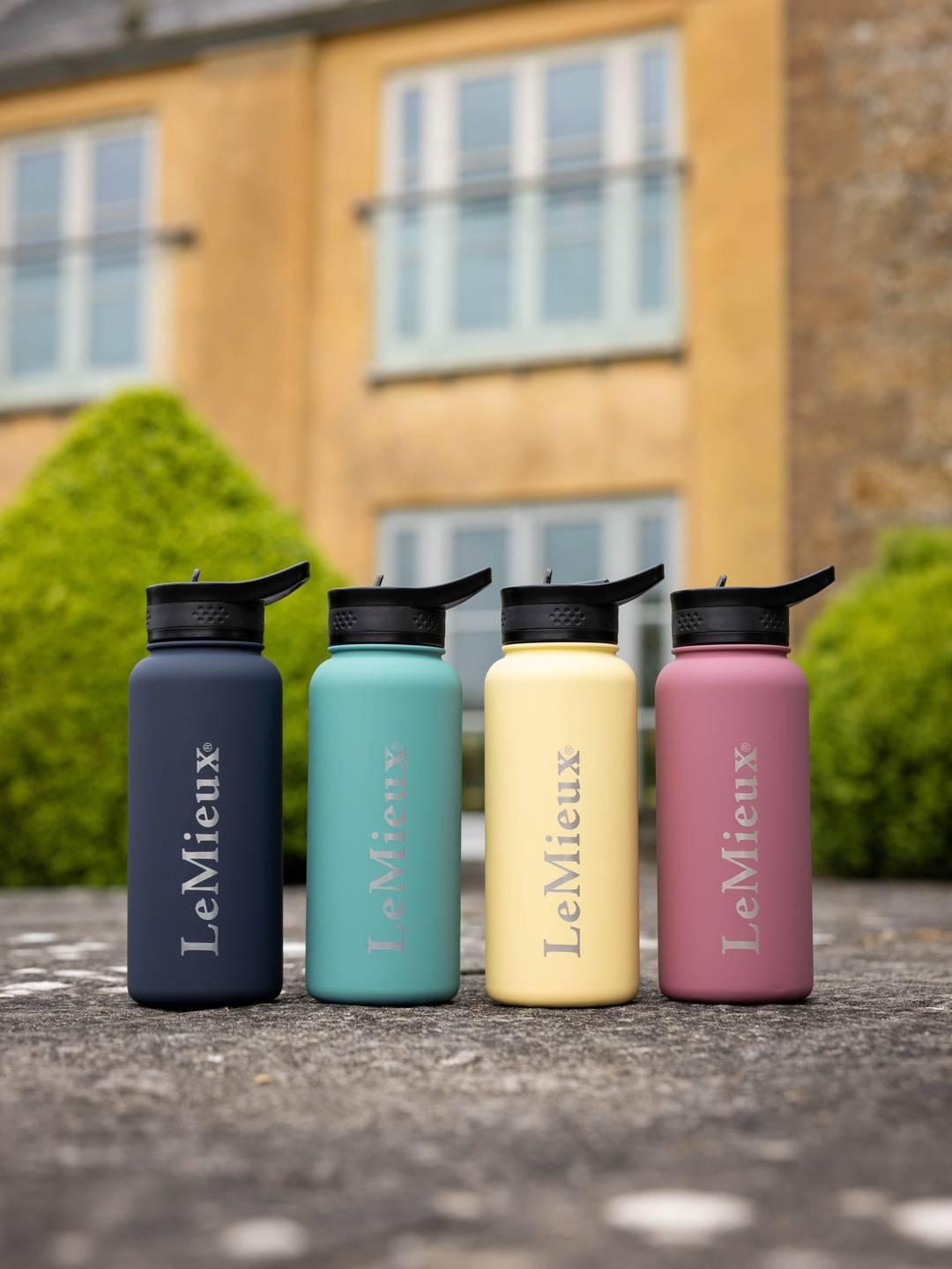 Front view of 4 assorted colors of the LeMieux Drinks Bottle set on pavement outside