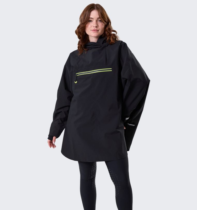 Model wearing Horseware H2O Poncho in black, front view with hood
