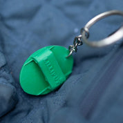 View of the green Horze Brush Key Chain on a blue zipper
