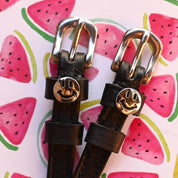 Close-up view of the Happy Face Mane Jane Spur Straps on a watermelon background