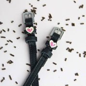 Front view 0f the Heart Smooshes Mane Jane Spur Straps on a plain background with scattered chocolate sprinkles 