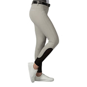 Side view of a model wearing the tan Equinavia Kristina Knee Patch Breeches on a white background