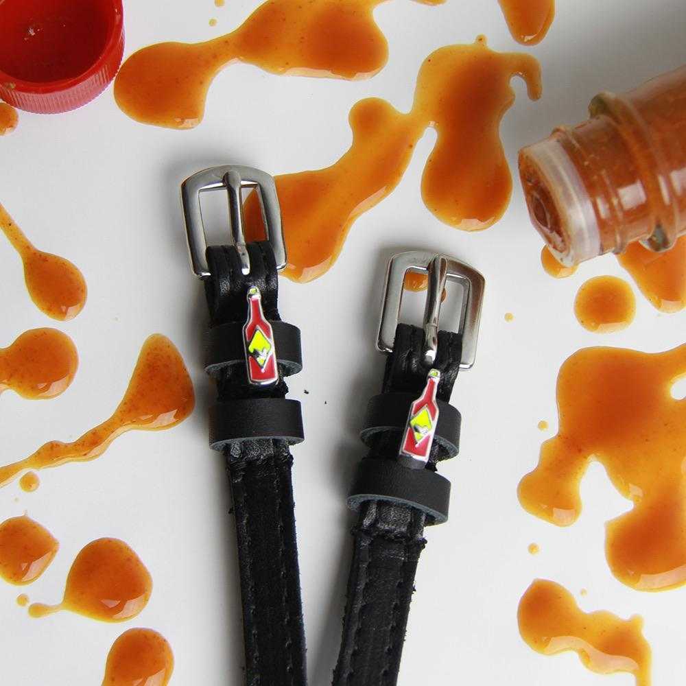 Close-up view of the Hot & Spicy Mane Jane Spur Straps on wood