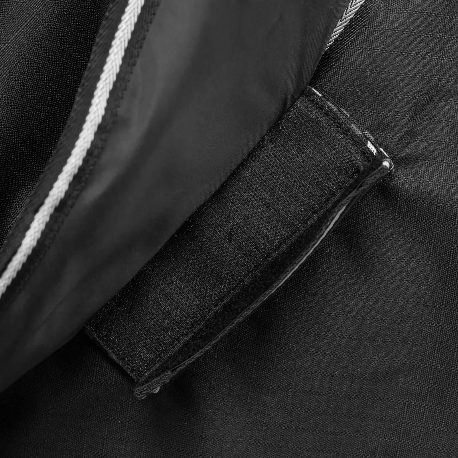 Close-up view of a velcro attachment to the blanket on the black Equinavia Norse Turnout Hood 0g