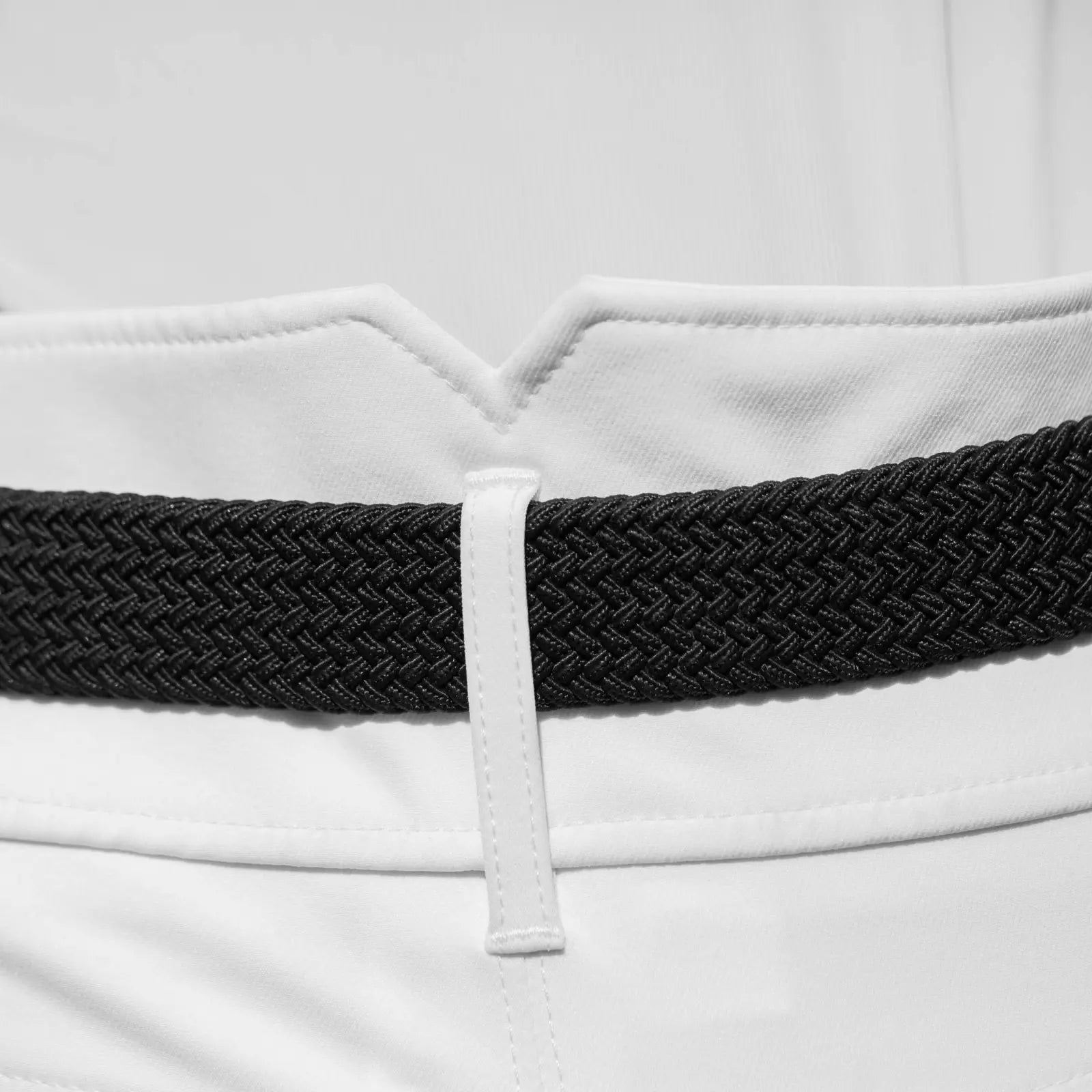 Close-up view of the black Equinavia Elsa Woven Stretch Belt on a white pair of breeches