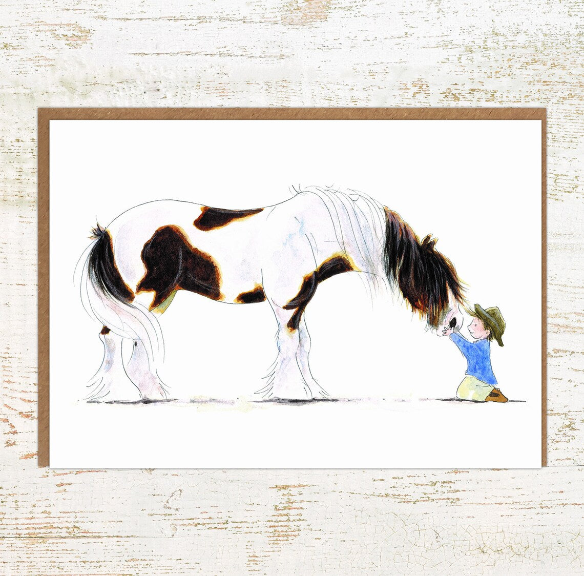 View of the Clydie Moment Pony Nut Greeting Card on a white washed wood background