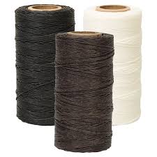 Three spools of cord or twine shown on a plain white background: one black, one dark brown, and one off-white/cream.