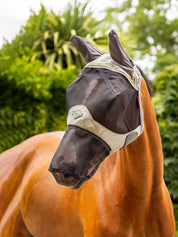 Horse standing outside wearing a LeMieux Visor-Tek Full Fly Mask in olive green