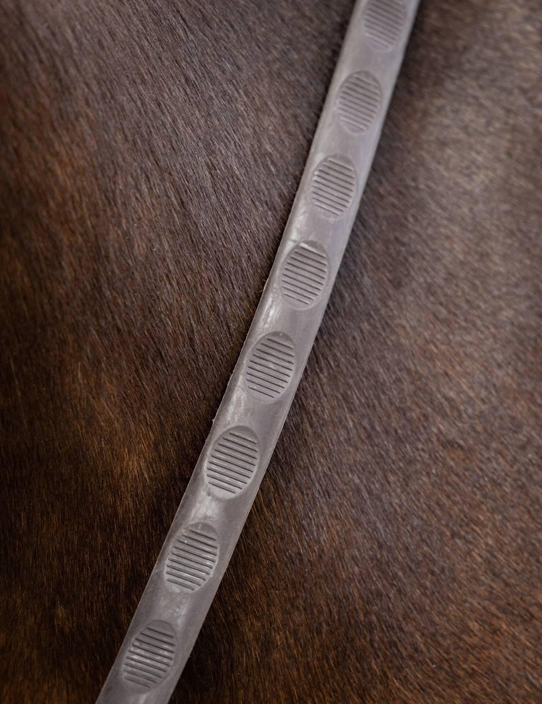 Close-up of brown LeMieux Magna Grip Rubber Reins on a horse’s neck showing textured grip