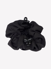 Bottom view of the black LeMieux Scrunchie With Crystal Hair Net with clips on a plain background