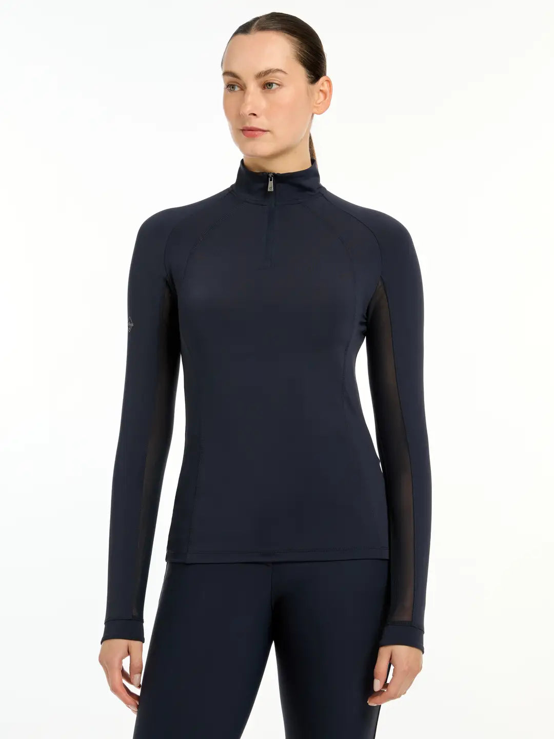 Front view of a model wearing the navy LeMieux Halle Lightweight Base Layer on a white background