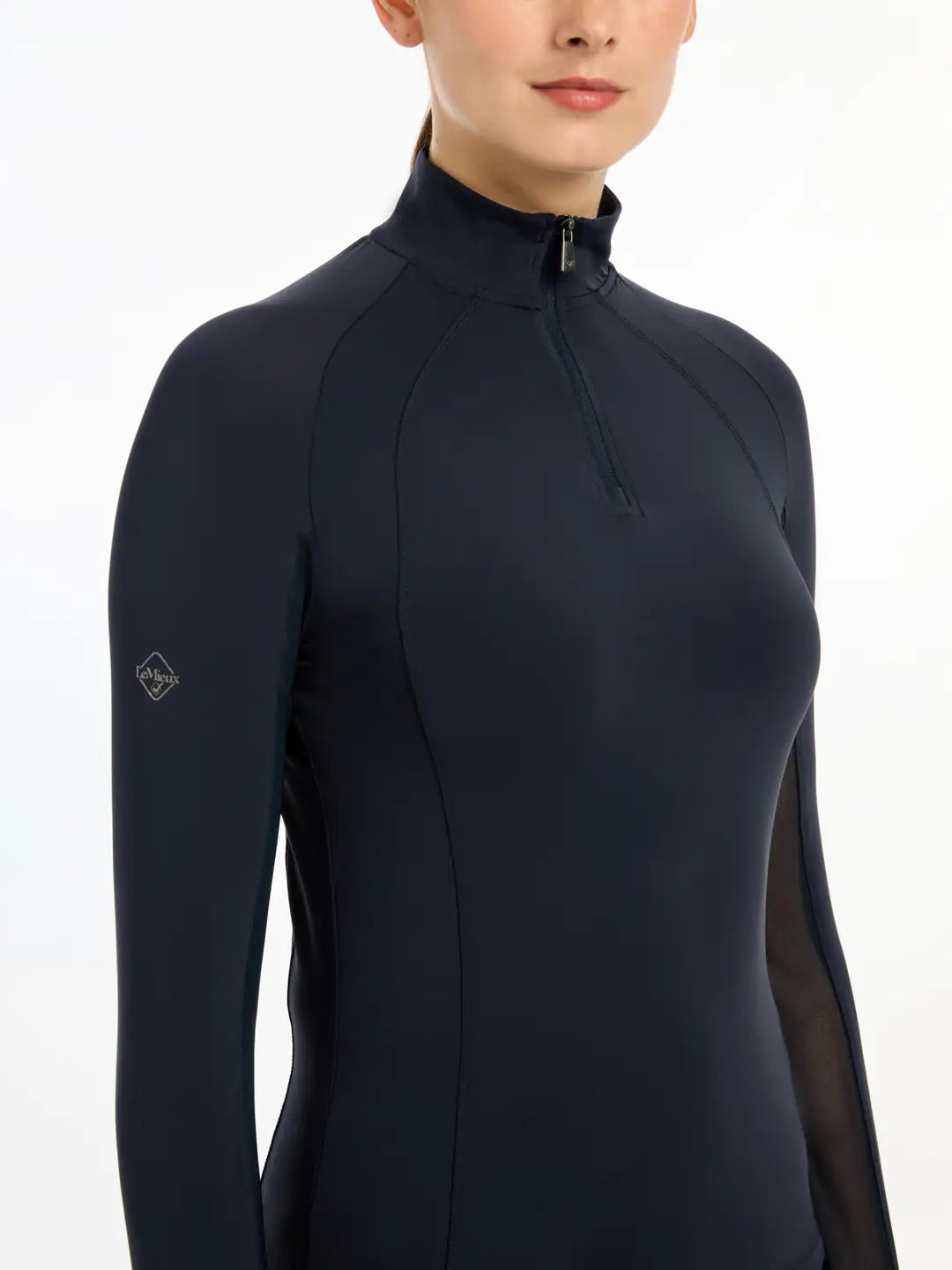 Close-up view of a model wearing the navy LeMieux Halle Lightweight Base Layer on a white background