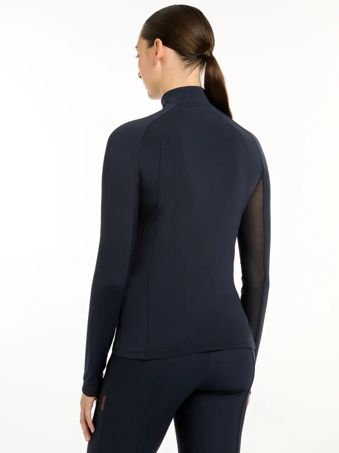 Front view of a model wearing the navy LeMieux Halle Lightweight Base Layer on a white background